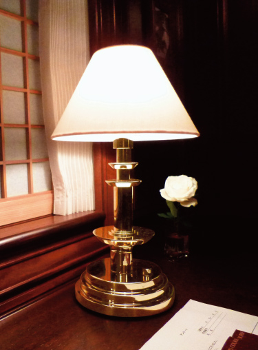 金属の削り出しの本体に、手づくりのランプシェードで柔らかい光を与えるテーブルランプ。