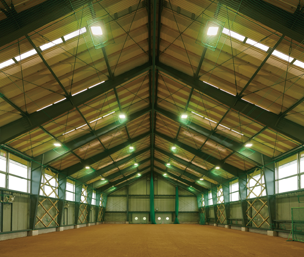 高天井用照明器具に加え、舞い上がる砂塵を排出する換気設備も備えた屋内練習場