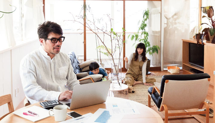 写真：リビングでPC作業をしている男性