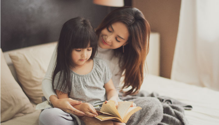 写真：リビングで絵本を読んでいる親子