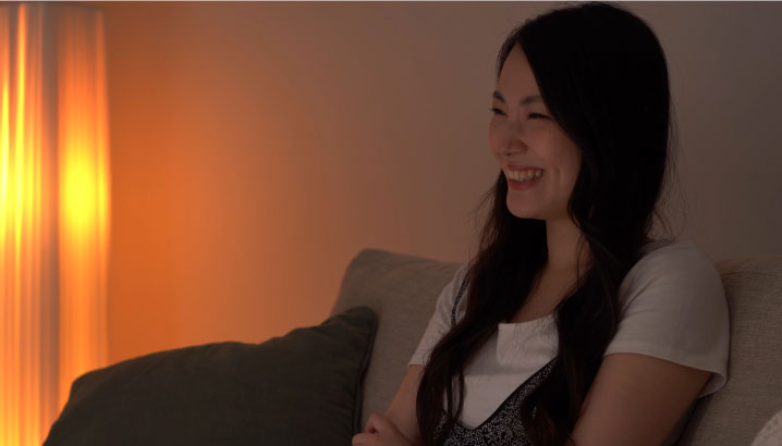 写真：薄暗い照明の部屋で過ごしている女性