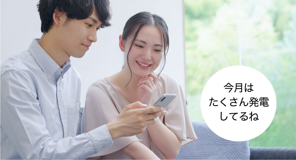 発電実績のイメージ画像です。「今月はたくさん発電してるね」と、夫婦でスマートフォンの画面を確認している画像です。