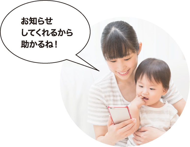 スマートフォンに届いたお知らせ通知を確認している親子の画像です。お知らせしてくれるから助かるね。