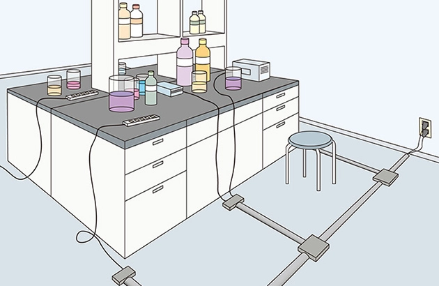 実験室で薬品がこぼれた際に、床の配線や電源にかかる恐れがある状況を示したイラスト。