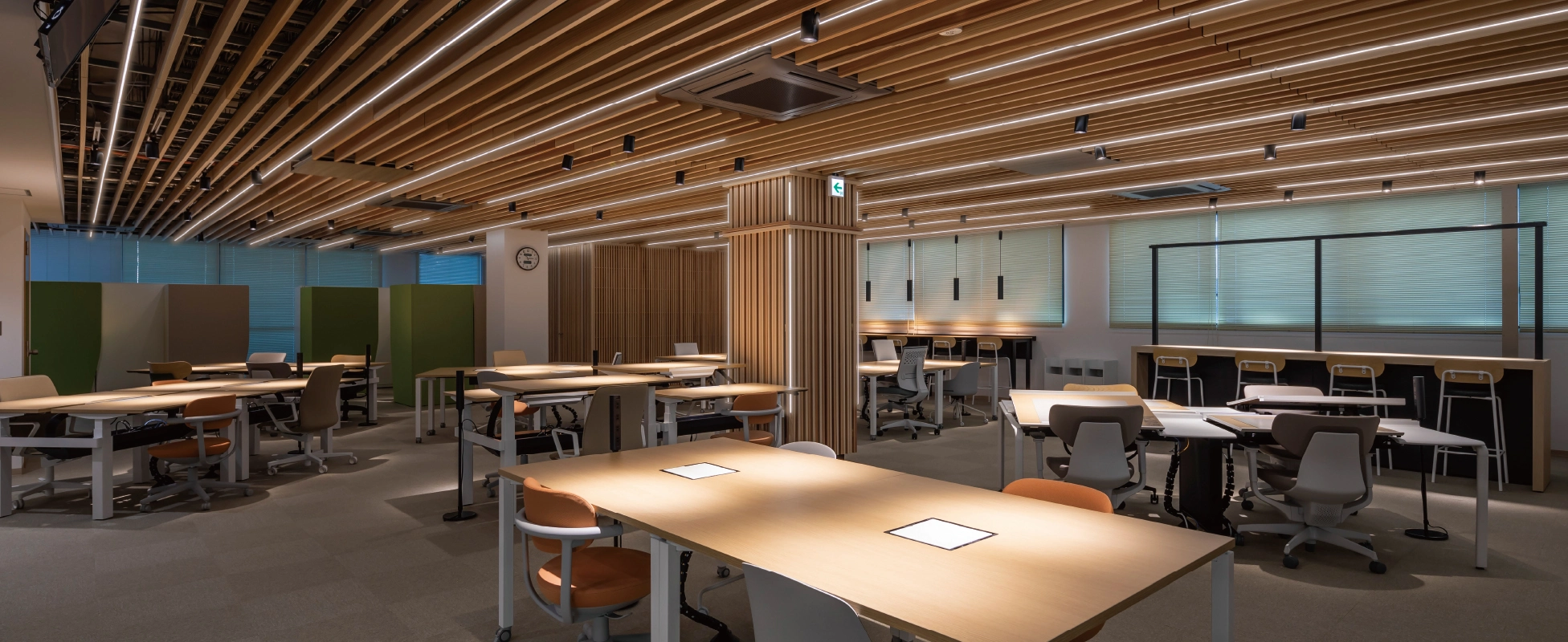 奈良県庁本庁舎のリニューアル後オフィス。木質のルーバー天井と照明器具を組み合わせ、温かみのある印象。ライン照明やペンダント、スポットライトを駆使し、業務に集中しやすい照らし方を実現している。