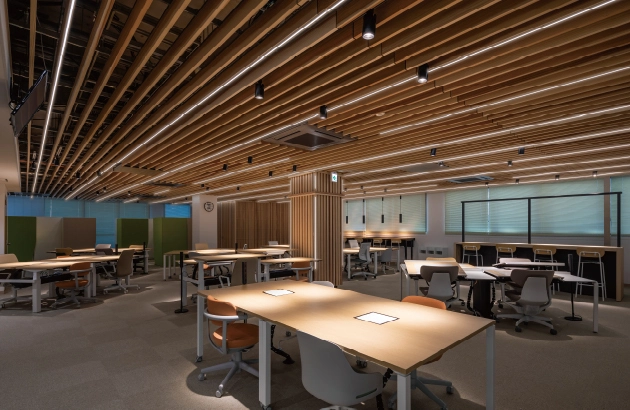 奈良県庁本庁舎のリニューアル後オフィス。木目調の天井に照明器具が整然と並び、温かみと機能性を両立した執務空間。