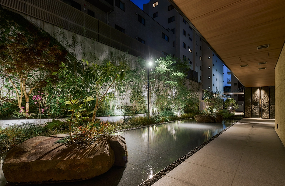 東急不動産「ブランズ白金台五丁目」ライトアップされた植栽と水盤が美しい夜のウォーターテラス