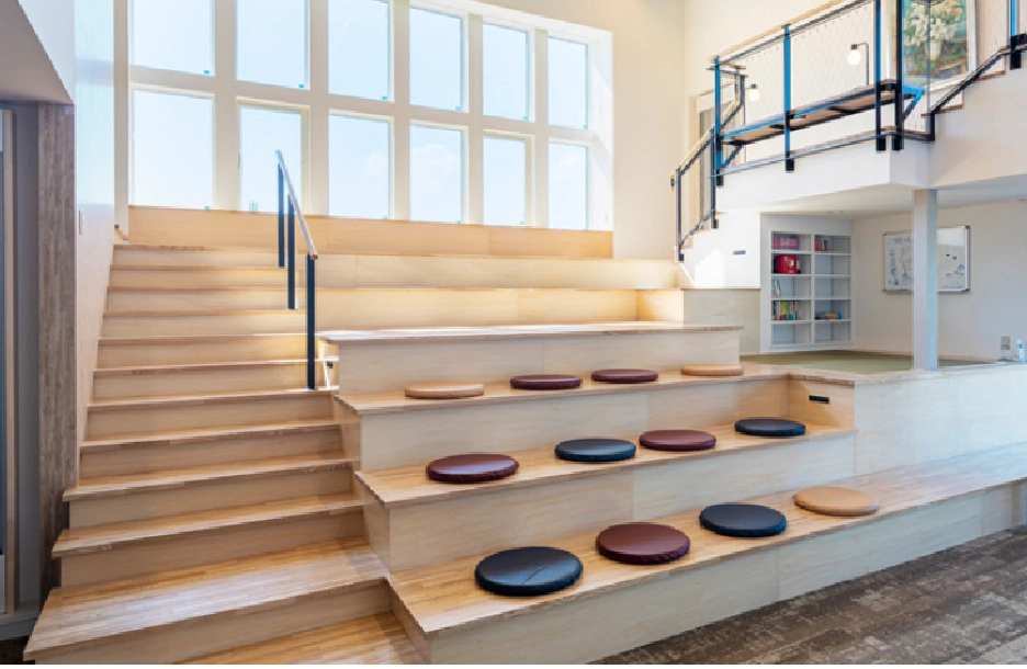 木製ステップに座席を設けた明るいコミュニティスペース