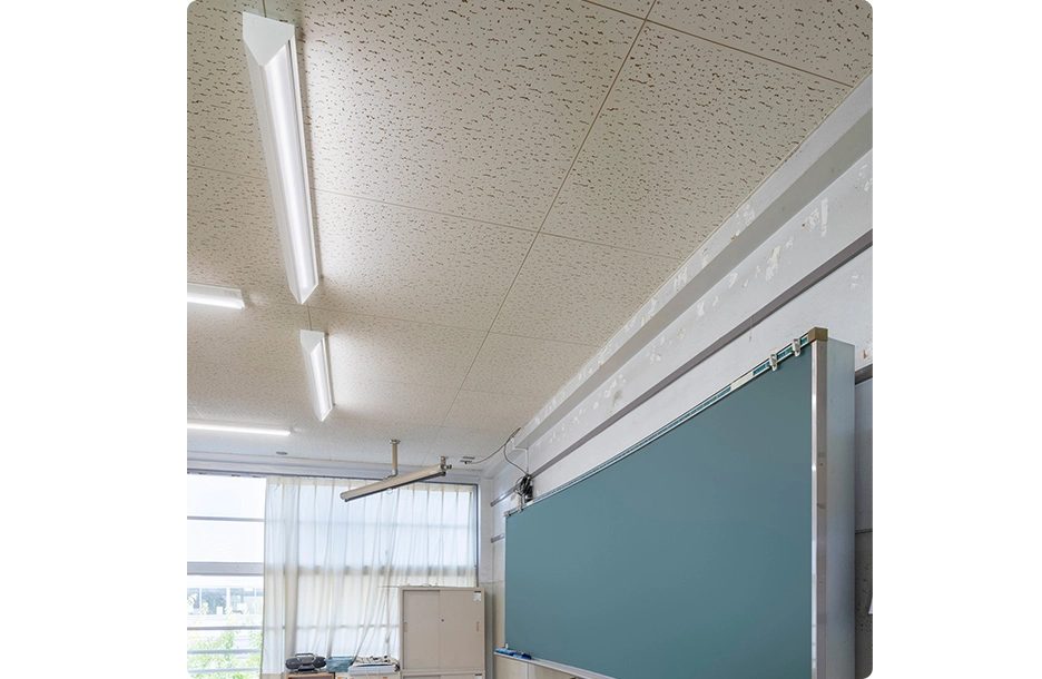 黒板灯で明るく照らされた教室の黒板