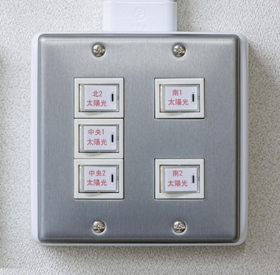安積行政センター壁面に設置された北・南・中央エリアの太陽光発電を制御するスイッチパネル