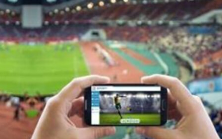 写真：スマートフォンで試合のライブ映像を見る手元