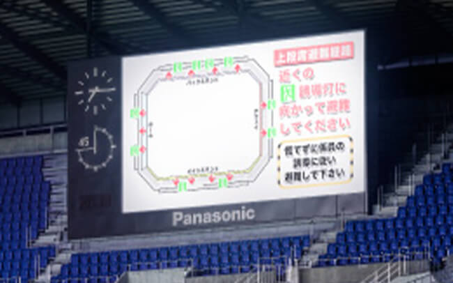 写真：スタジアム内の大型モニターに表示された避難経路