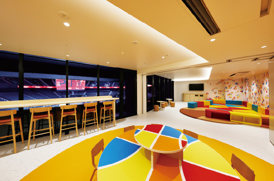 観戦席の後ろにプレイスペースを設置し、子ども連れでも観戦が楽しめるように設計された