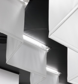 図：短い膜材の上端に、天井に埋め込んだ照明がある。両側の長い膜材が光を受ける