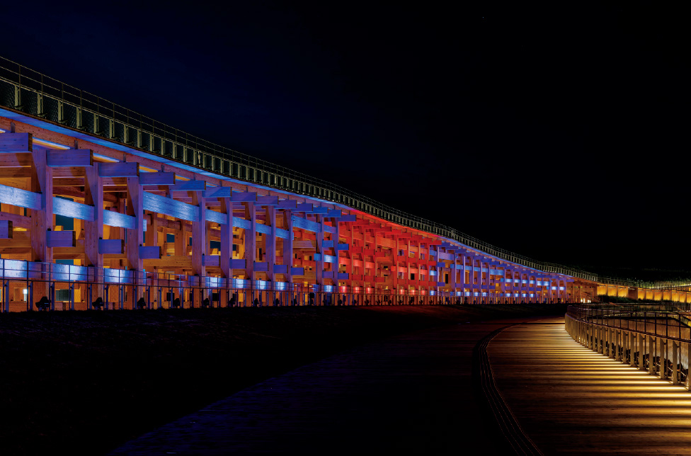 リング上の二段屋根もフルカラー投光器によりシンボリックにライトアップされ、その存在感を高めている。(ミャクミャクカラー)