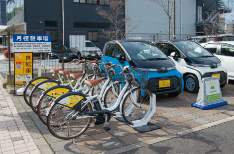 多治見駅南口前のコンビニ駐車場に配置された小型EV（右）と電動アシスト自転車（左）