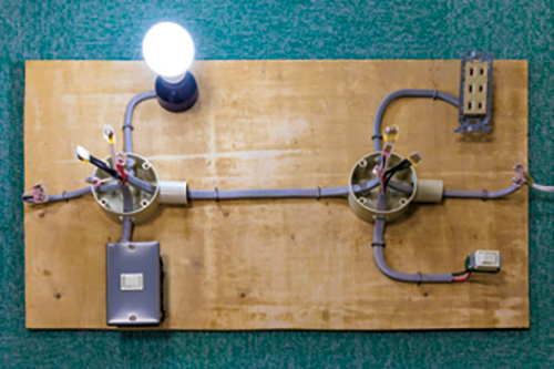 出前授業の際に持参するキット。スイッチを押すと電球が点灯する仕組みやコンセントに電化製品を差し込むと動く仕組みを電気回路を使って説明します。